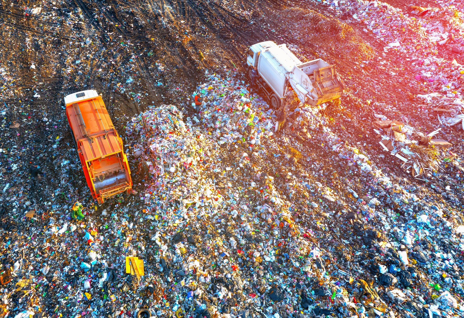 Garbage truck unloads rubbish in landfill, aerial view. Landfill waste disposal.